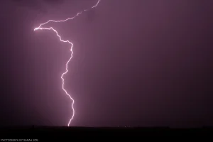 A singular bolt of lightning illuminates the night skies of rural, high plains North Dakota.