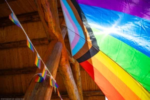 The sun flares through the fabric of a massive flag at the 2023 Lincoln County Pride Festival.