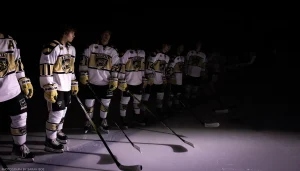The Bismarck Bobcats roster waits for the national anthem on a blue line that stretches into the void.