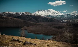 Mount St. Helens as seen from the Coldwater Ridge Visitor Center in late March of 2024. The lake was formed in the eruption of 1980, when volcanic debris blocked the flow of the creek. Prolifically active, the mountain is indeed smoking in this shot, however subtly.
