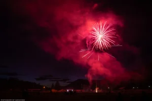 A red firework explodes in an almost flower-like pattern at the annual 4th of July celebration in Troy, Montana.