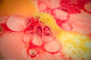 The foam pouring out of an especially delicious-looking bath bomb creates an abstract scene, equal parts tasty and toxic.