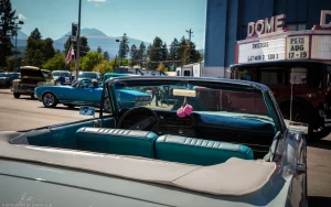 A classic convertible faces the Dome Theater marquee at the Ignite the Nites car show in Libby, Montana.
