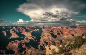 A small thundershower blooms over the Grand Canyon at dusk.